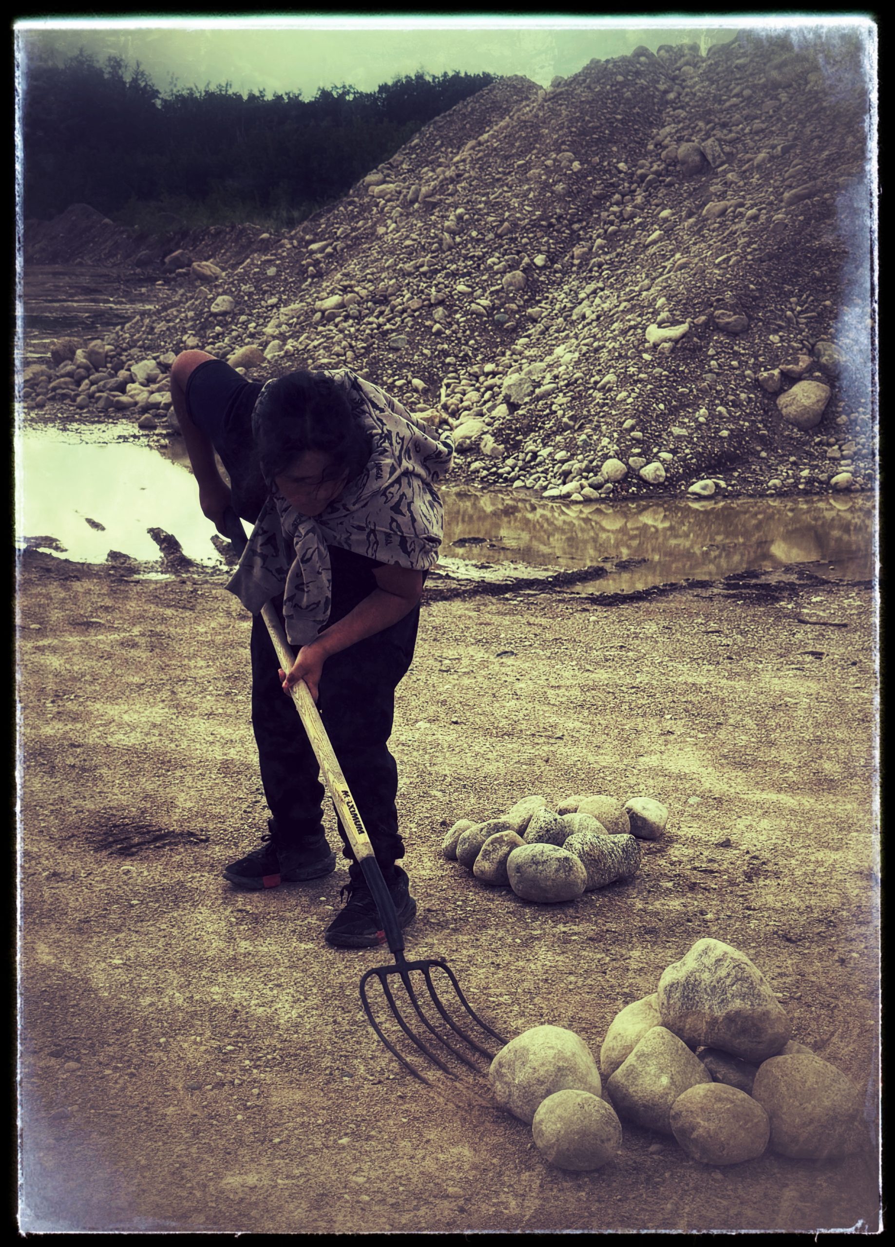 A participant carrying a rock during an outdoor activity